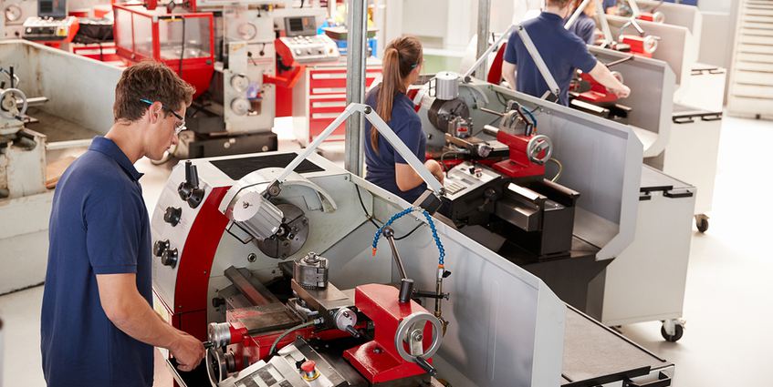 Machine workers dressed in blue at work.