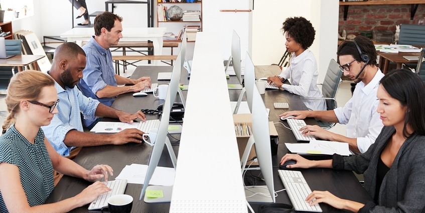 Group of workers looking at desktop monitors.