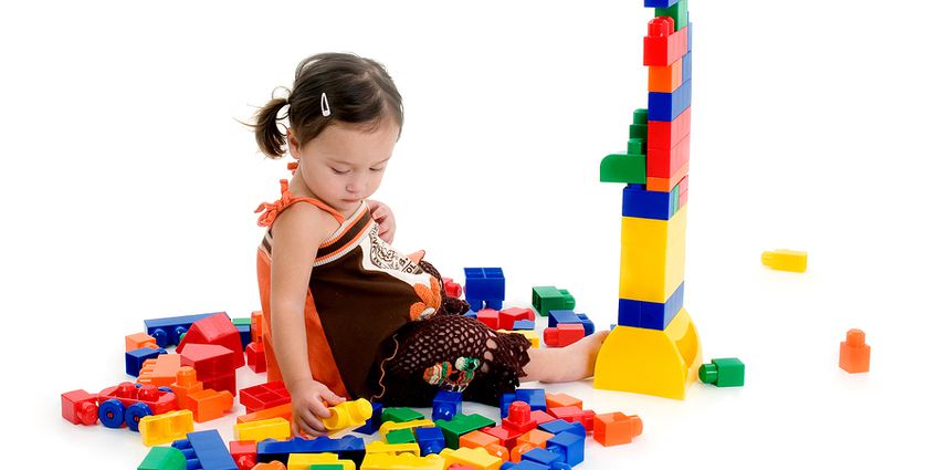 Young child playing with colorful plastic blocks.