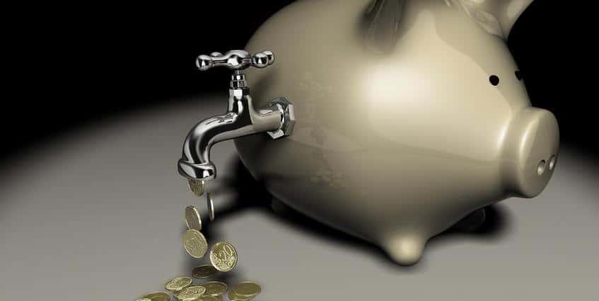 Piggy bank with a spigot pouring out coins.