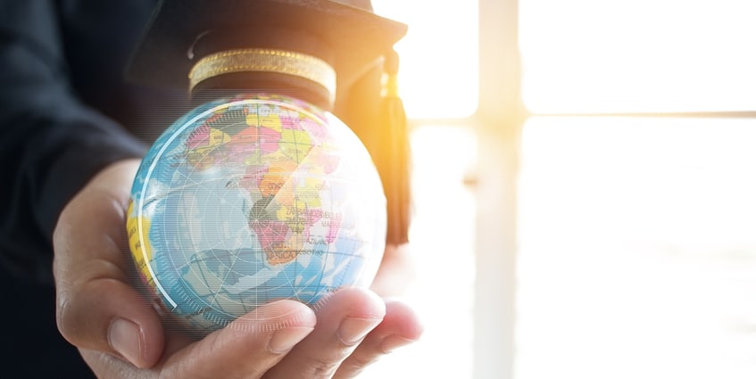 Person holding a model of the earth in the palm of his hand.