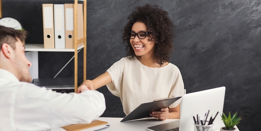 Woman shaking hands with a potential customer.