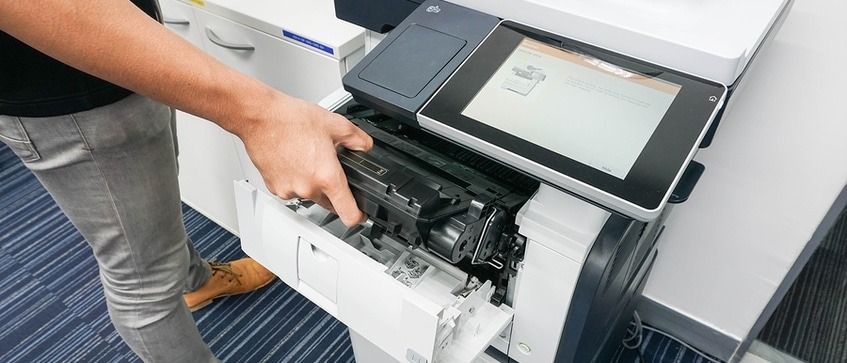 Person working on fixing a copier.