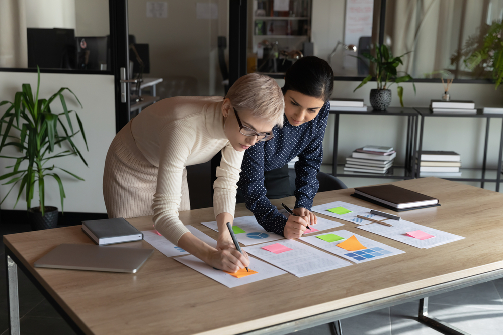 Two business people doing workflow on paper